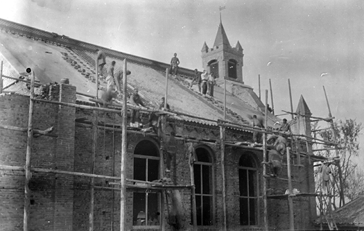 Photo of workers setting the roof tile of the new church in Kiaohsien, China, 1913